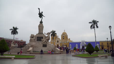 Hermosa-Plaza-Principal-Con-Una-Gran-Estatua-Antigua-En-El-Centro-Antiguos-Edificios-Coloniales-Y-El-Monumento-A-La-Libertad-En-La-Ciudad-De-Trujillo,-La-Libertad,-Perú