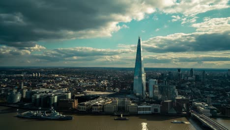 Zeitrafferaufnahme-Der-Londoner-Stadtlandschaft-Mit-Der-Themse-Und-Modernem-Shard-Gebäude-Während-Mystischer-Wolken-In-Bewegung