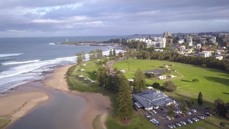 Aerial-fly-over-the-Wollongong-beach-with-cityscape-in-the-background-on-a-cloudy-day
