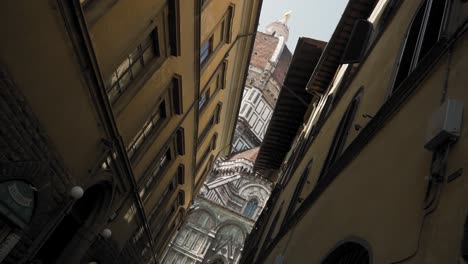 Low-angle-view-from-narrow-street-on-iconic-Duomo-cathedral-Florence-Italy