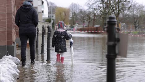 Mother-And-Daughter-Walk-On-The-Flooded-Sidewalk-In-Eltville-Town-In-Germany