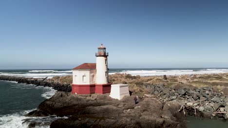 The-historic-Coquille-River-Lighthouse-along-the-Oregon-coast-of-the-Pacific-Ocean,-aerial-orbit