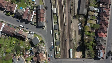 National-rail-train-passing-through-gentrified-suburban-london-drone-shot
