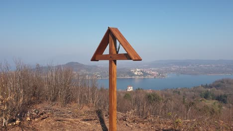Wooden-cross-on-mountain-Motta-Grande-at-Arona-and-Maggiore-Lake-in-background