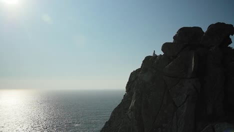 Solitary-woman-think-while-watching-to-the-horizon-at-a-cliff-at-the-Atlantic-ocean