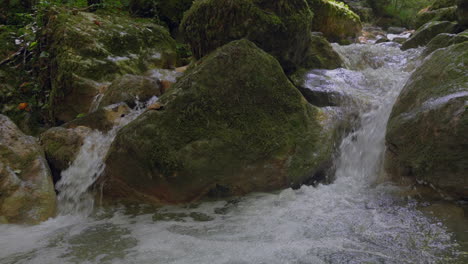 Nahaufnahme-Eines-Plätschernden-Kleinen-Wasserfalls-In-Zeitlupe-In-Der-Wilden-Natur-Der-Schweiz---4K-Schwenkaufnahme-In-Grünen-Bergen-Mit-Moos-Und-Bäumen-Im-Sommer