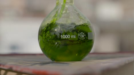 Green-Fluid-Pouring-Into-Flask---slow-motion,-close-up