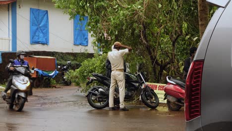 Indischer-Polizist-Ersetzt-Hut-Bei-Polizeikontrolle-Am-Straßenrand-Im-Ländlichen-Goa,-Indien