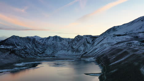 Sonnenlichtreflexion-Auf-Dem-Seewasser-Mit-Majestätischer-Bergkette-Im-Hintergrund,-Luftaufnahme