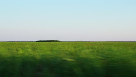 Driving-On-A-Country-Road-Passing-By-Beautiful-Lush-Green-Fields-In-Galati,-Romania