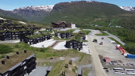 Myrkdalen-Mountain-Village---Volando-Sobre-Costosas-Y-Enormes-Casas-Recreativas-Negras-Con-Techo-De-Hierba-Y-Dirigiéndose-Al-Hotel-Myrkdalen-En-El-Centro---Noruega
