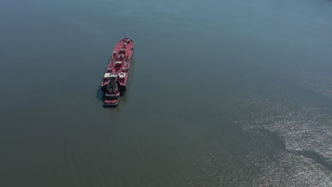 Eine-Drohnenansicht-Eines-Großen-Roten-Lastkahns,-Der-An-Einem-Sonnigen-Tag-Im-Hudson-River-In-New-York-Vor-Anker-Liegt