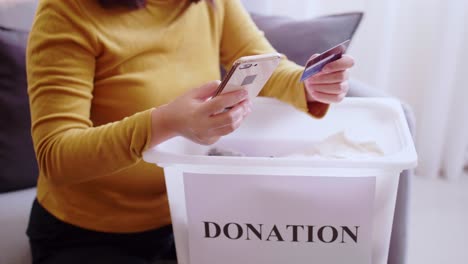 Detail-of-female-hands-making-a-donation-with-a-credit-card