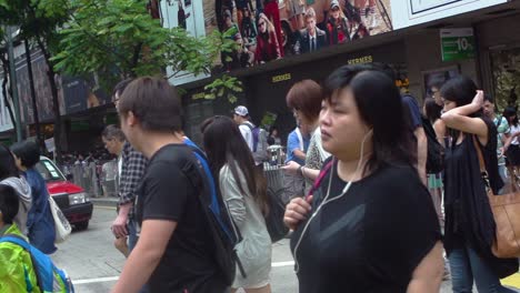 Panning-wide-shot-of-multiple-Chinese-persons-and-Hong-Kong-citizens-crossing-crosswalk