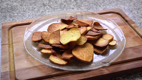 Hand-Picks-Fried-Sweet-Potato-Chips-In-A-Clear-Glass-Platter
