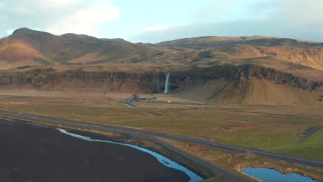 Establishing-shot-of-Seljalandsfoss-waterfall-front-face,-Iceland-aerial-landscape-with-scenic-cascade