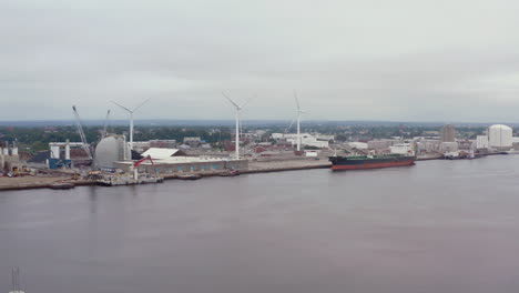 Frachtschiff-Dockte-An-Einem-Bewölkten-Tag-Mit-Windkraftanlagen-Am-Hafen-An