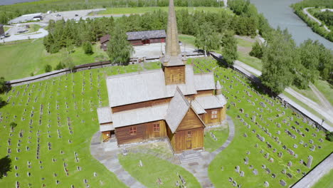 Iglesia-De-Madera-De-Lom-Con-Lápida-Cerca-De-Bovra-Y-Río-Otta-En-Lom,-Noruega