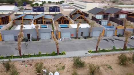 Street-view-of-a-hotel-cottage-complex-in-Saudi-Arabia-city,-orbital-drone-scene