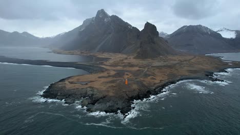 Islands-Dramatische-Küste-In-Den-östlichen-Fjorden-Mit-Orangefarbenem-Leuchtturm-An-Islands-Ringstraße