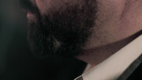 Side-view-close-up-of-caucasian-business-man-in-suit's-thick-black-beard
