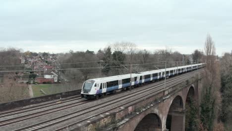 Dolly-back-profile-drone-shot-of-TfL-rail-train-over-Wharncliffe-viaduct