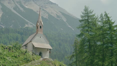 Close-up-shot,-Scenic-view-of-a-church-on-the-top-of-the-hill-in-Italy,-Reschensee-behind-the-camera