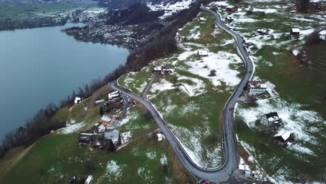 Cars-driving-up-a-serpentine-on-a-winter-mountain-in-Amden,-Switzerland