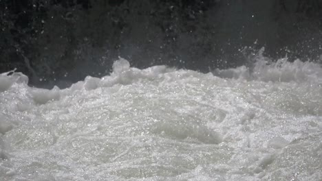 Slow-Motion-close-up-of-splashing-natural-waterfall-in-nature-during-sunny-day