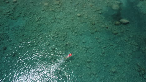 Luftaufnahme-Einer-Person,-Die-Im-Türkisfarbenen-Wasser-Schwimmt