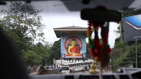 Cameraman-captures-the-statue-of-Lord-Buddha-from-inside-a-car-while-driving-at-Kandy,-Sri-Lanka