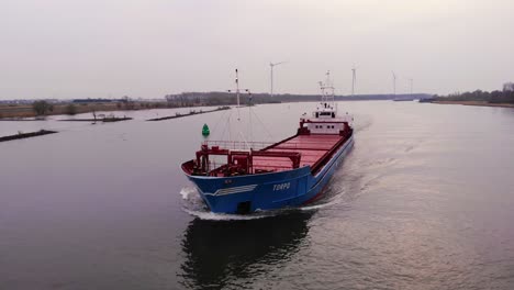 Aerial-Circle-Dolly-Around-Forward-Bow-Of-Torpo-Cargo-Ship-Navigating-Oude-Maas-On-Cloudy-Day