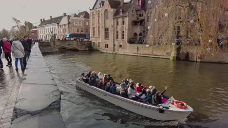 Tourists-taking-a-boat-trip-through-the-Bruges-canals