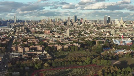 Aerial-rise-over-Brooklyn-New-York-City-with-housing-projects-and-the-BQE-Expressway,-Manhattan-and-downtown-Brooklyn-skylines-in-the-distance