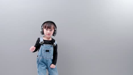 Kind-Hört-Musik-Mit-Headset-Und-Trägt-Jeans-Auf-Grauem-Hintergrund-Im-Studio