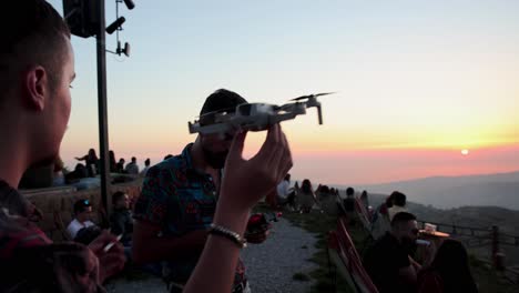 Two-friends-starting-a-small-drone-ready-to-fly-off-into-the-sunset-at-cherry-frozen-lounge
