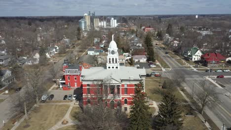 Historic-Eaton-County-courthouse-in-Charlotte,-Michigan-with-drone-flying-over-with-skyline