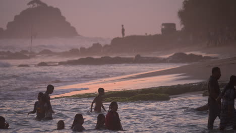 Menschen-Planschen-Bei-Sonnenuntergang-Während-Der-Goldenen-Stunde-Im-Meer