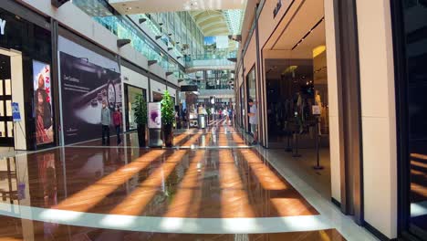 Luxusboutiquen-In-Den-Shoppes-In-Marina-Bay-Sands-In-Singapur-Mit-Käufern,-Die-Durch-Das-Einkaufszentrum-Schlendern
