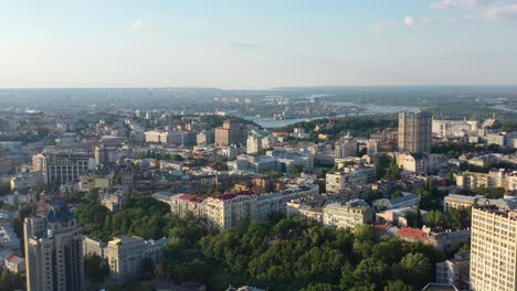 Aerial-drone-video-of-downtown-skyline-buildings-and-Dnipro-river-in-Pecherskyi-district-of-Kyiv-Oblast-Ukraine-during-sunset