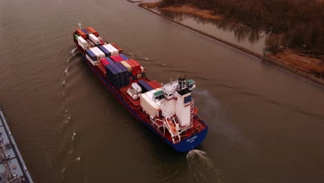 Aerial-View-Of-Stern-of-JSP-Carla-Cargo-Ship-Travelling-Along-Oude-Maas-On-Overcast-Day-With-Another-Ship-Passing-Close-By