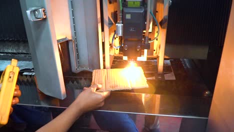 Testing-new-industrial-laser-on-piece-of-cardboard,-handheld-view