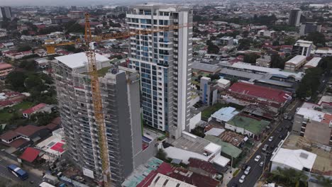Cinematic-aerial-shot-of-a-tower-crane-constructing-a-skyscraper-in-Costa-Rica