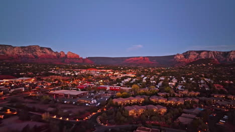 Wide-revealing-twilight-drone-shot-of-Sedona-Arizona-with-the-mountains-in-the-distance