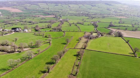 Aerial-forward-shot-of-the-East-Devon-Countryside-on-a-sunny-day-with-the-Blackdown-Hills-in-the-distance