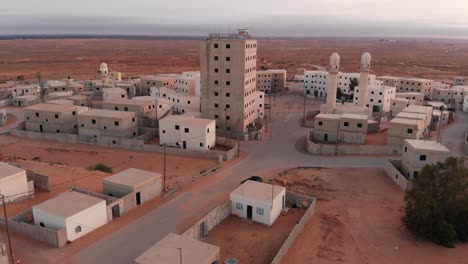 aerial-shot-of-a-big-building-in-an-old-empty-poor-city-in-the-desert-in-palestine-near-Gaza-at-morning