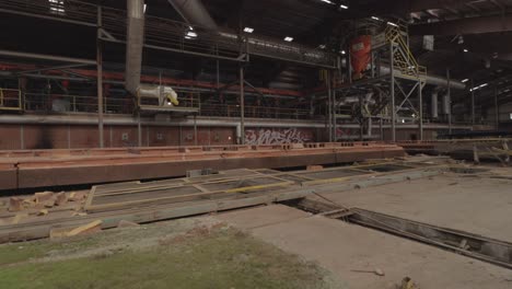 Slider-Footage-of-Machinery-in-an-Abandoned-Brick-Factory-with-Graffiti-and-Mossy-Stones