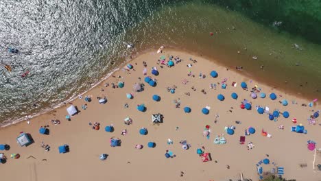 Tropischer-Strand-Mit-Sonnenschirmen---Urlaubskonzept---Luftaufnahme-Von-Oben-Nach-Unten