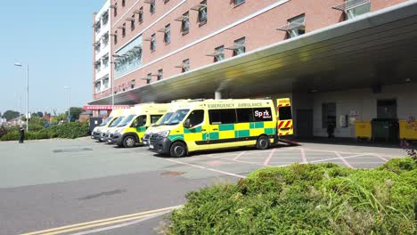 Medical-emergency-ambulance-parked-in-Whiston-hospital-cark-park-accident-entrance-pan-left