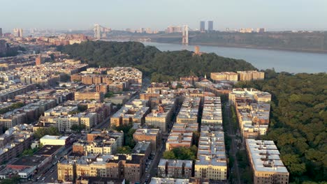 Aerial-pan-over-the-Inwood-neighborhood-of-New-York-City,-the-Cloisters-and-the-George-Washington-Bridge-in-the-distance
